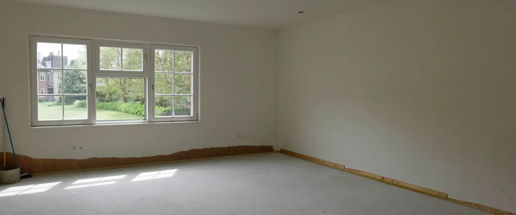 Lege woonkamer met een kale, schoon gefreesde betonvloer, klaar voor een nieuwe vloer